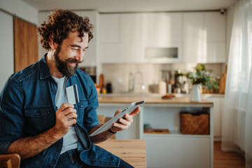 Man using credit card and tablet for online shopping