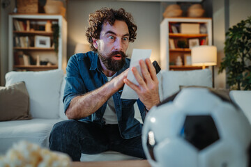 Excited man reacting to successful football betting ticket