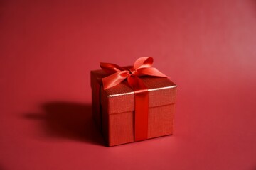 A beautifully wrapped red gift box with a vibrant red ribbon