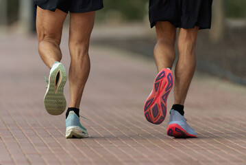 Two men running on the sidewalk, training for a marathon