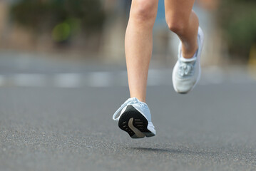 Child runner feet running on road close up on shoe , marathon running race