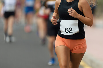 Woman runner running on marathon race on sunny days