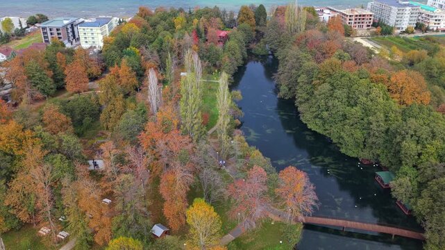 Aerial video of Drilon National Park with a wooden bridge and Lake Ohrid under autumn light.
