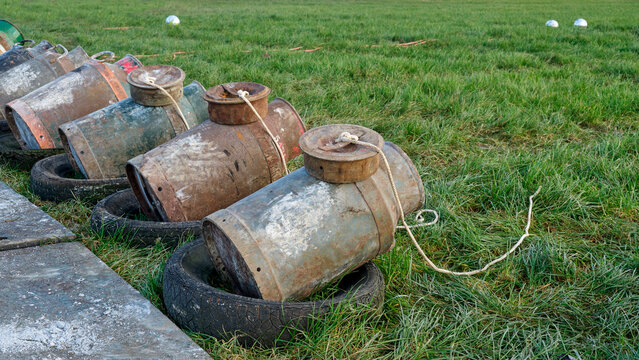 Old milk cans in a row. Carbide shooting or carbidschieten in dutch is a tradition in the Netherlands and usually takes place on New Year's Eve. The goal is to make a loud bang after the carbide