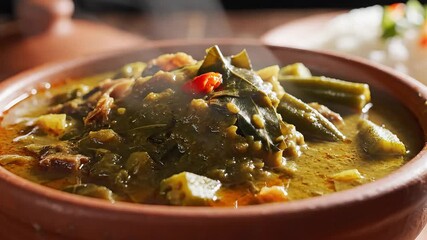 A closeup shot of a delicious steaming traditional vegetable stew possibly a hearty okra and lentil curry served hot in a rustic earthenware bowl emanating warmth and rich aromas perfect for a comfor.