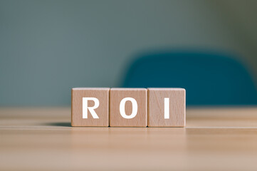 ROI (Return on Investment) on wooden cubes on desk, Financial analysis and profit management...