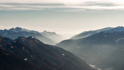 Naklejka premium View to Pinzolo village in the valley of Italian Alps mountains during ski resort winter season, sport and tourism