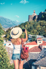 Young woman taking photography with smarthpone of beautiful old city, Travel destination in Albania, Gjirokaster