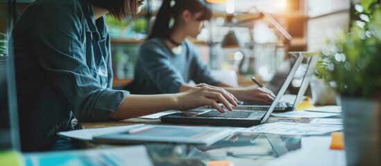 Collaboration at Work: Focused colleagues engage in intense computer work, their dedication illuminated by the bright desk lamps.
