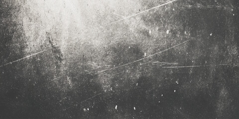 A grayscale abstract image featuring a textured surface with dark and light areas and scattered linear markings