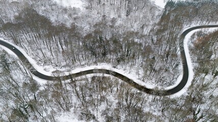 Winding Winter Road Through Snow-Covered Forest, Aerial View