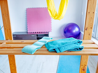 wooden shelf with towels and resistance band in bright gym studio
