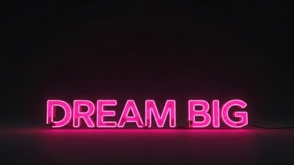 Dream big neon sign glowing in pink light. Motivational message on a dark background. Inspiration concept with copy space
