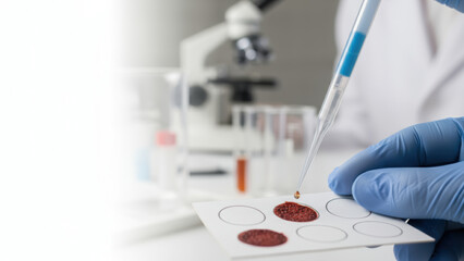 Laboratory pipette with blue liquid drops on blood sample slide for longevity research using advanced technology in clinical science