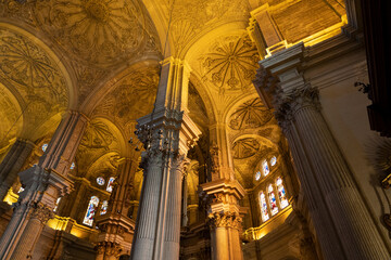 Intricate architecture with illuminated columns and ceiling.. Cathedral of Malaga, Spain