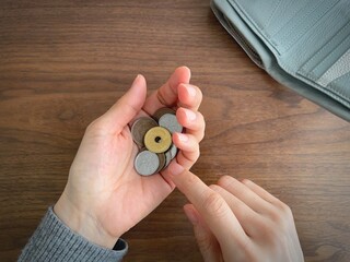 Counting small coins in hand, low budget and saving money concept