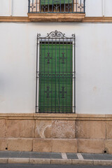 Green window with decorative ironwork on white wall.. Ronda, M&aacute;laga, Spain