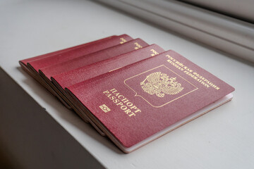 Russian passports stacked near a window