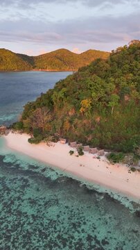 Bird's-eye view of Linapacan Tourists Camp, in the beach with hills and beautiful cloudy sky as a backdrop, in New Culaylayan Island, Philippines
