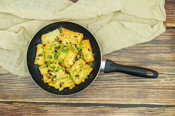 Fried tofu is placed in a frying pan