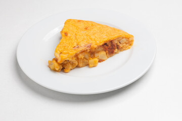 Spanish omelet slice with chorizo and potatoes on plate for traditional spanish cuisine