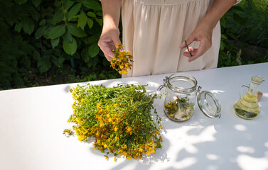 St. John's Wort Oil Recipe Step 5: Woman Adding Flowers to Jar