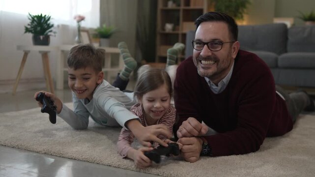 Happy father and children playing video games at home