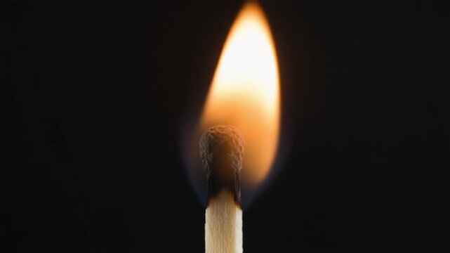Matchstick ignites and burns with bright flame.