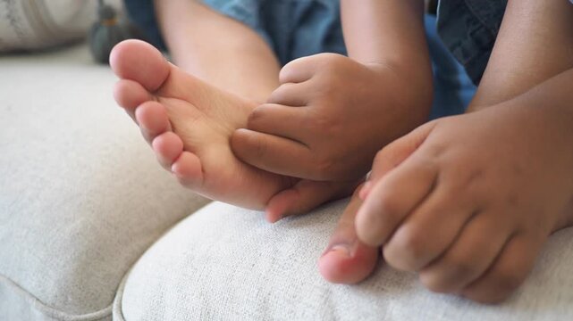 Child plays with feet while sitting on a couch
