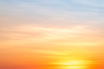 Sunset or sunrise sky with a vibrant gradient of orange, gold, and soft blue. Clear atmosphere with wispy clouds. Peaceful, natural light background. hope, freedom, new day and inspirational Concepts