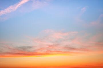 Fototapeta premium Sunset or sunrise sky with a vibrant gradient of orange, gold, and soft blue. Clear atmosphere with wispy clouds. Peaceful, natural light background. hope, freedom, new day and inspirational Concepts