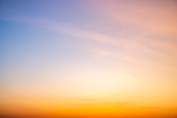 Sunset or sunrise sky with a vibrant gradient of orange, gold, and soft blue. Clear atmosphere with wispy clouds. Peaceful, natural light background. hope, freedom, new day and inspirational Concepts