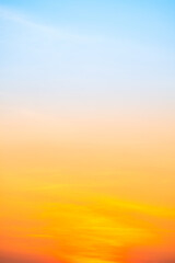 Sunset or sunrise sky with a vibrant gradient of orange, gold, and soft blue. Clear atmosphere with wispy clouds. Peaceful, natural light background. hope, freedom, new day Concepts, Vertical