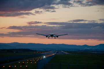 夕暮れの飛行場に着陸するジェット機
