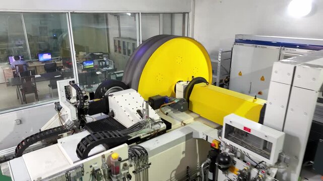 Industrial workshop with yellow large roll material processing equipment in operation