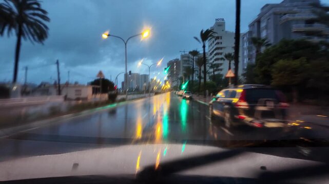 Car driving point of view on a rainy night city street