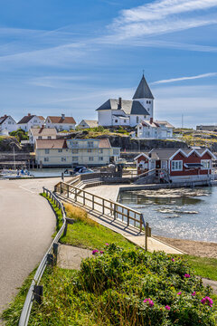 Scenic coastal village on Tjorn, Sweden with white church on hill, harbor and boats