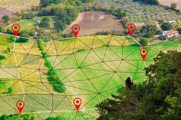 FARMLAND WITH DIGITAL GRID AND LOCATION PINS FOR REAL ESTATE AND AGRITECH - GPS mapping and land plot management concept on hilly terrain for construction industry and precision farming