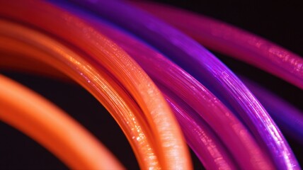 Vibrant Cables: Abstract Close-Up of Intertwined Orange and Purple Electrical Wires on Black Background