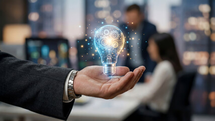 Business person holding glowing digital light bulb with gears