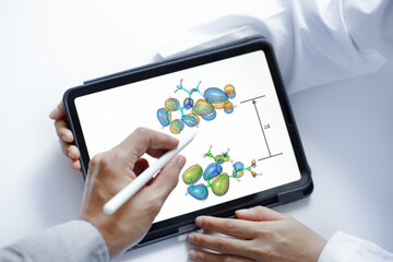 A scientist uses a digital pen to point at a 3D molecular structure, explaining the electron density between two molecular model orbitals, as shown on a digital tablet with a white background.