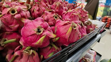 Fresh red dragon fruit Hylocereus costaricensis displayed on supermarket shelf in grocery store organic produce section