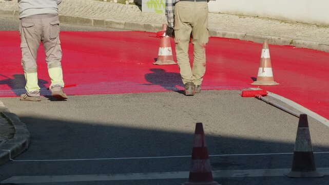 Process of painting for speed restricting road surface marking with red paint in residential areas. 