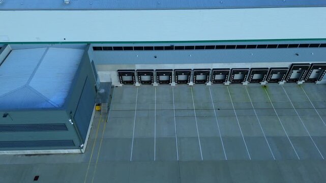 Aerial view of distribution centre loading bays with grey concrete contrasting against the white lines and building, Kettering, Kettering, United Kingdom.
