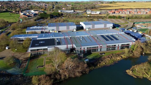 Aerial view of Nene Business centre with its modern buildings, lush greenery, and reflective waters, creating a serene yet functional landscape, Irthlingborough, United Kingdom.
