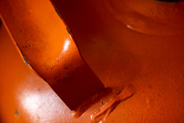 Close up of an orange gas cylinder handle highlighting the concept of energy fuel.