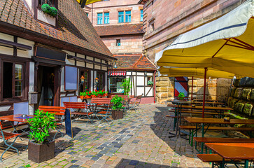 Obraz premium Old town Nuremberg city historical center Craftsmen's Courtyard with traditional half-timbered houses, typical colorful buildings, street restaurants and outdoor cafes, Bavaria state, Germany