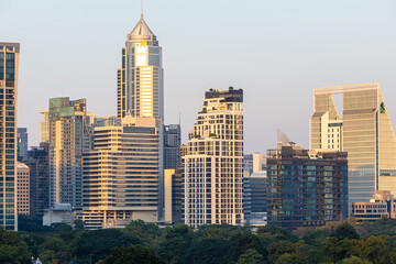 Modern office building and condominium with green tree Lumphini park sunset sky