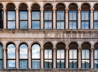 Obraz premium Historic classic building facade with arched windows and classical columns in Venice, Italy