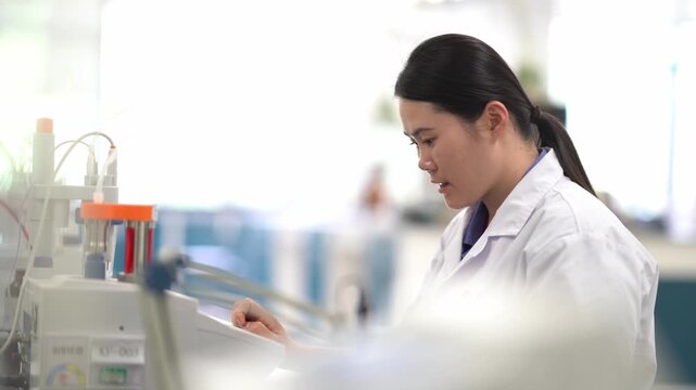Female researcher focused on reviewing experimental data records in a laboratory setting